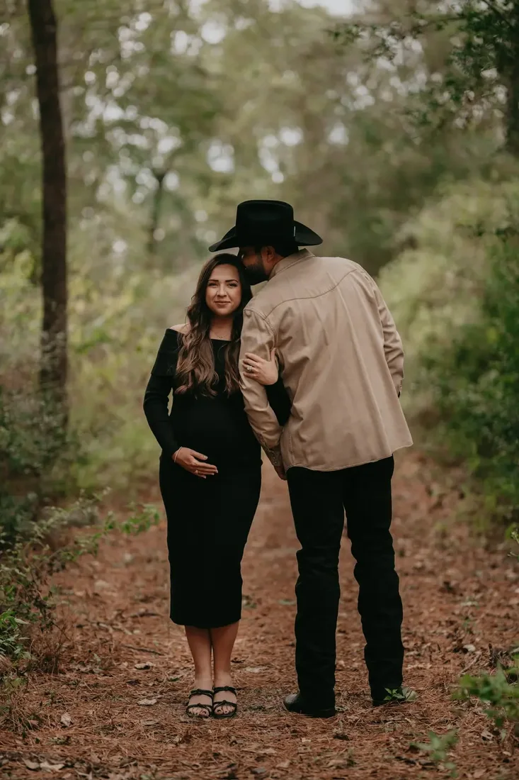 Maternity portrait, couple walking a wooded path, cowboy hat