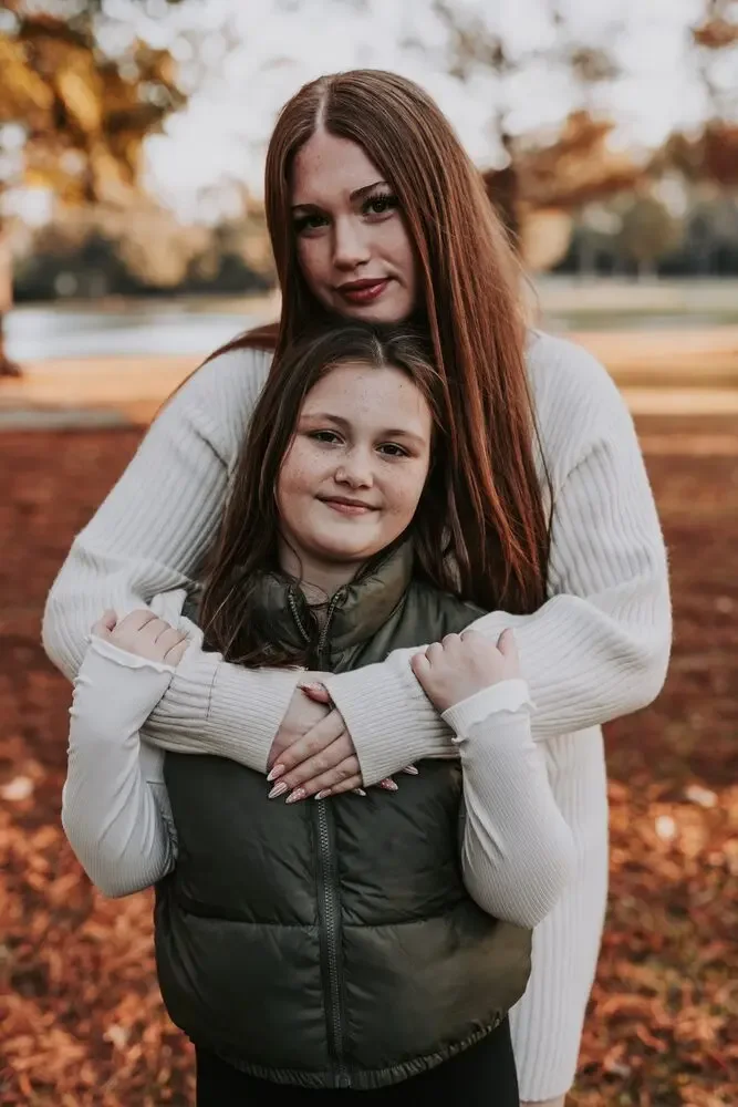 Two sisters embracing outdoors in autumn